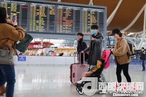 旅客帶著孩子前往辦票柜臺辦理登機手續(xù)。　殷立勤 攝