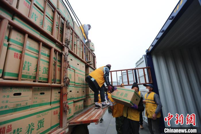 圖為鐵路裝卸作業(yè)人員正在將云南特色農(nóng)產(chǎn)品裝入集裝箱?！詈?攝
