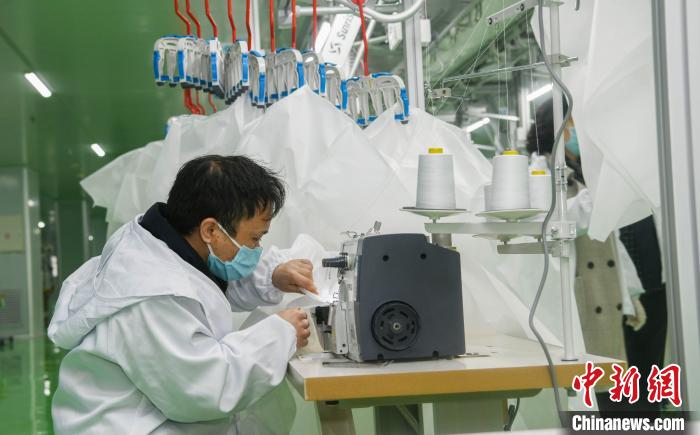 工人生產(chǎn)防護(hù)服，保障抗疫物資供應(yīng)。廣安市委宣傳部供圖