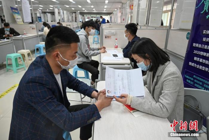 4月14日，招聘者在查看求職者簡歷。<a target='_blank'  data-cke-saved- >中新社</a>記者 王剛 攝