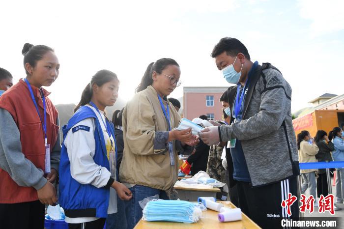 7月7日，考生在拉薩三高考點(diǎn)外領(lǐng)取口罩?！『闻罾?攝