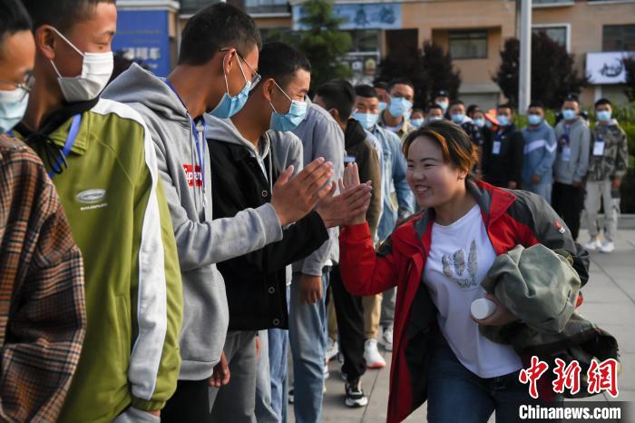 7月7日，拉薩三高考點(diǎn)外，領(lǐng)隊老師與考生擊掌鼓勁加油?！『闻罾?攝