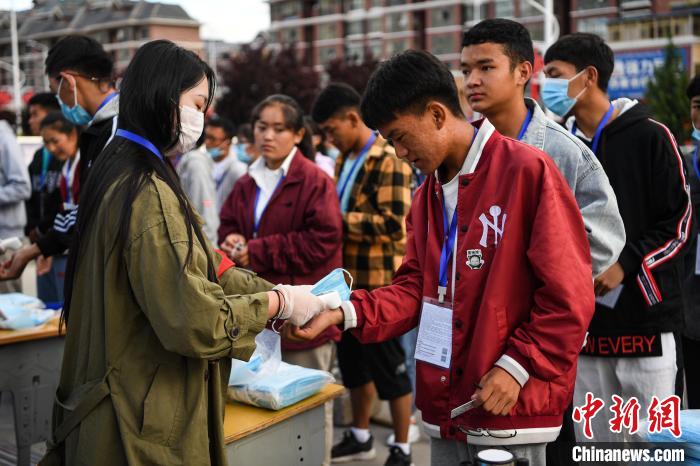7月7日，考生在拉薩三高考點(diǎn)外測量體溫。　何蓬磊 攝